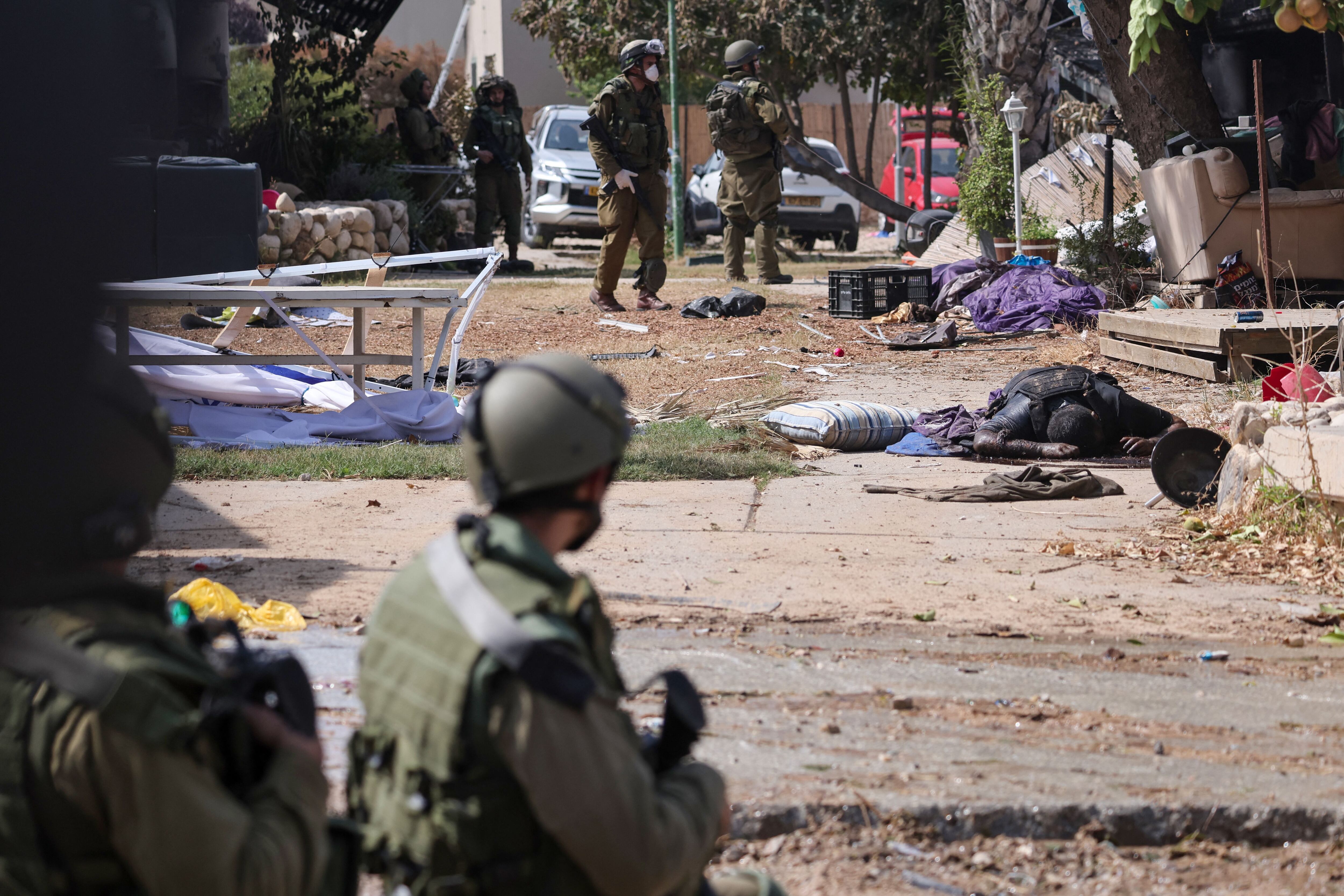 Soldados recorren el kibutz de Kfar Aza, en el sur de Israel, cerca de Gaza (AFP)