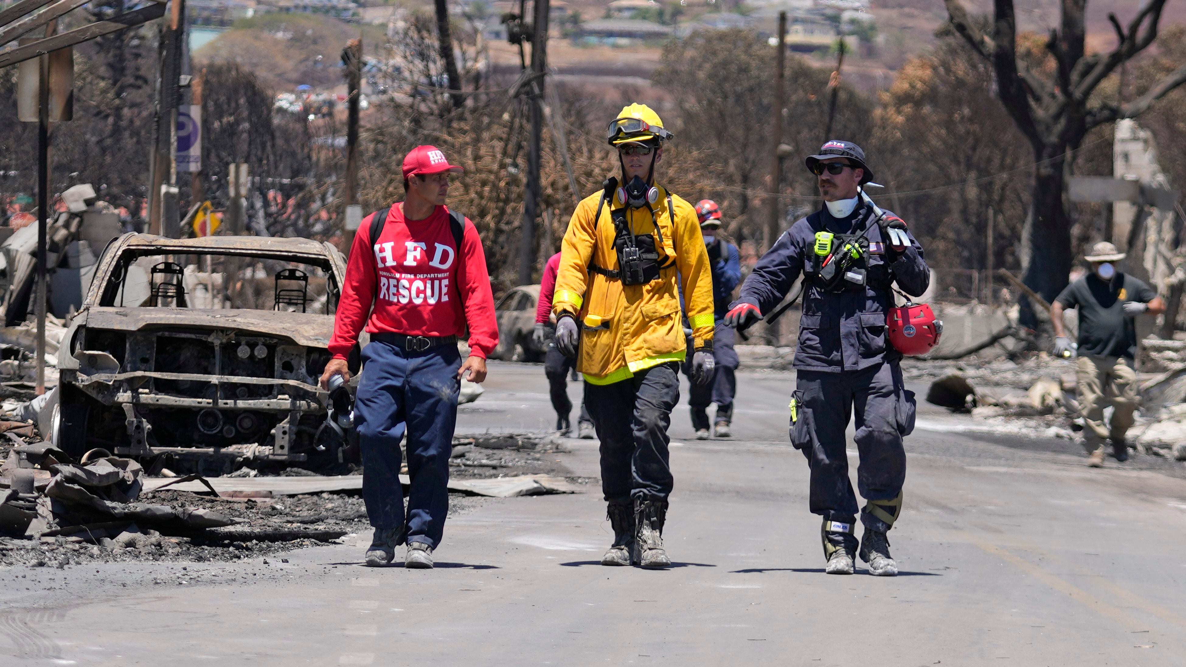 Miembros del equipo de búsqueda y rescate caminan por una calle el sábado 12 de agosto de 2023 en Lahaina, Hawai, tras un incendio que provocó graves daños. (AP Foto/Rick Bowmer)