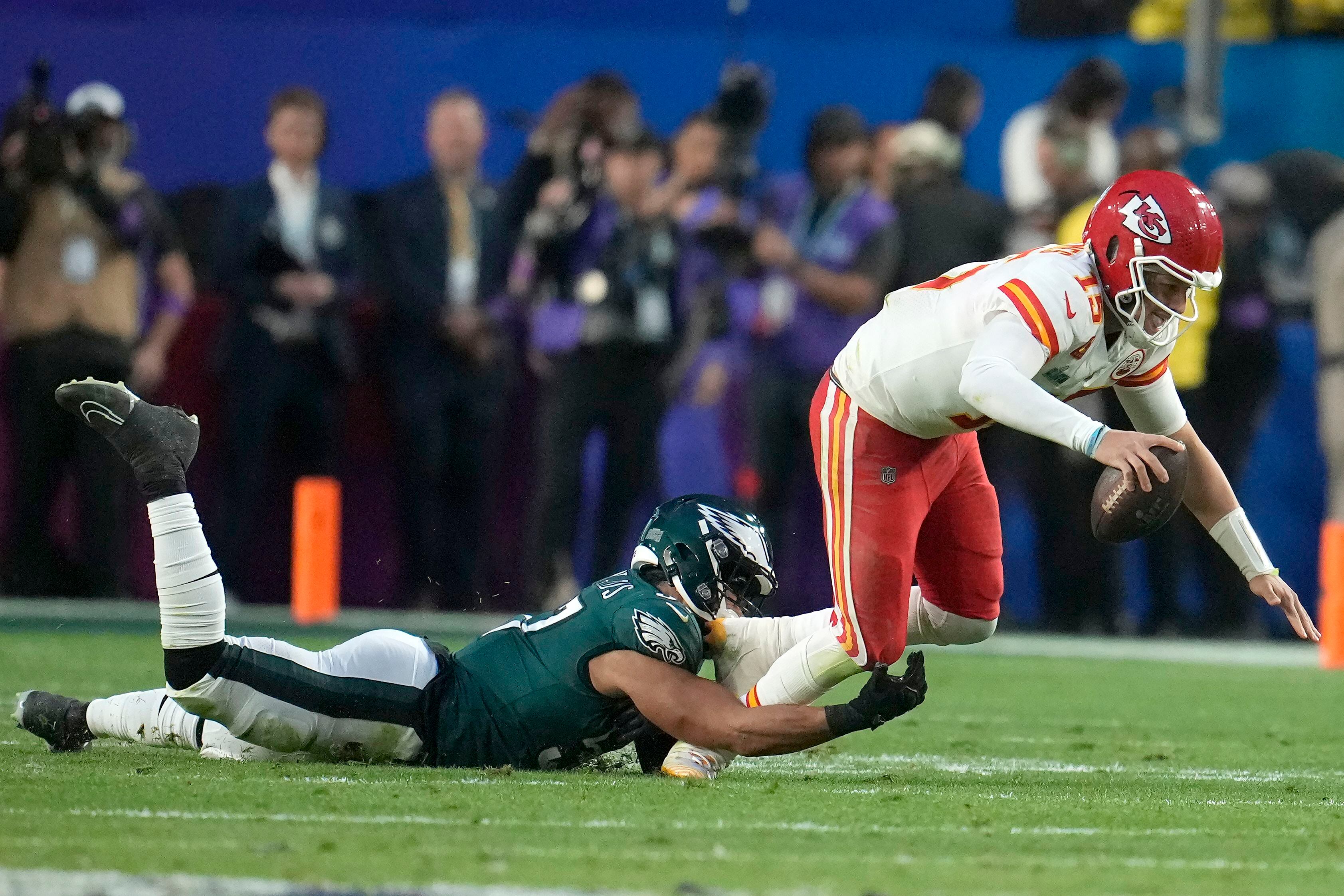 El linebacker T.J. Edwards (izquierda) de los Eagles de Filadelfia derriba al quarterback Patrick Mahomes de los Chiefs de Kansas City durante el primer tiempo del Super Bowl 57, en Glendale, Arizona, el domingo 12 de febrero de 2023. (AP Foto/Marcio J. Sánchez)