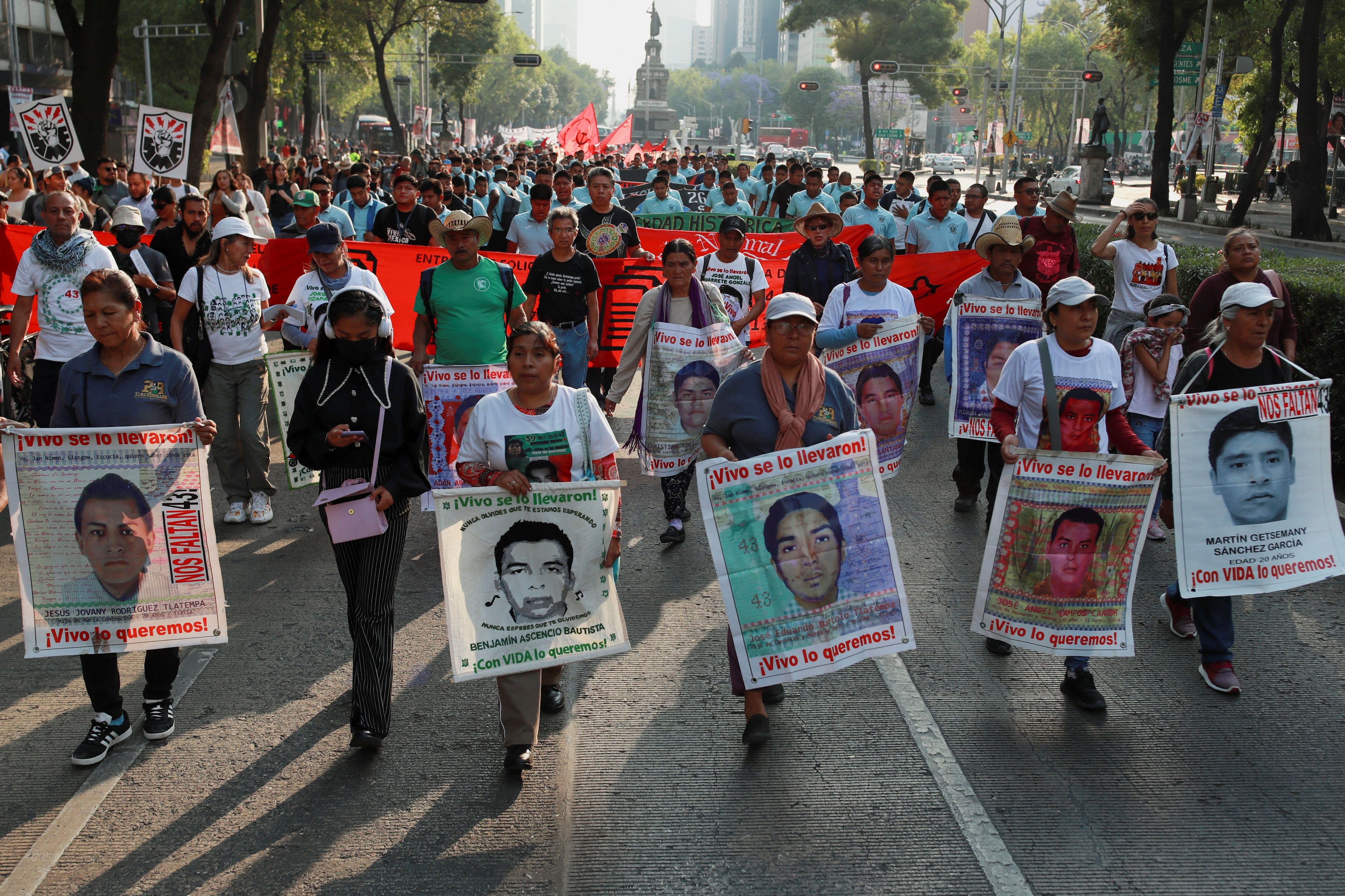 Relatives hold banners with images of the missing students from the Ayotzinapa Teacher Training College during a march to demand justice for their loved ones, in Mexico City, Mexico March 26, 2024. REUTERS/Henry Romero