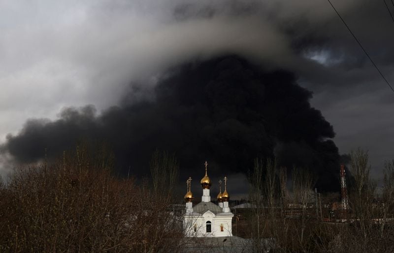 Una iglesia ortodoxa delante de una refinería de petróleo que se incendió tras un ataque con misiles cerca de la ciudad portuaria de Odesa, en medio de la actual invasión de Rusia, en Ucrania