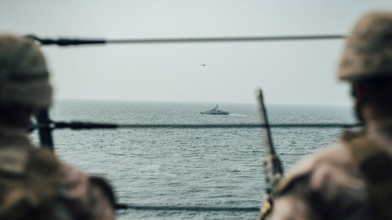 Infantes de Marina estadounidenses observan una lancha rápida de ataque iraní desde el buque USS John P. Murtha durante un recorrido por el estrecho de Ormuz (Donald Holbert/U.S. Navy vía REUTERS)