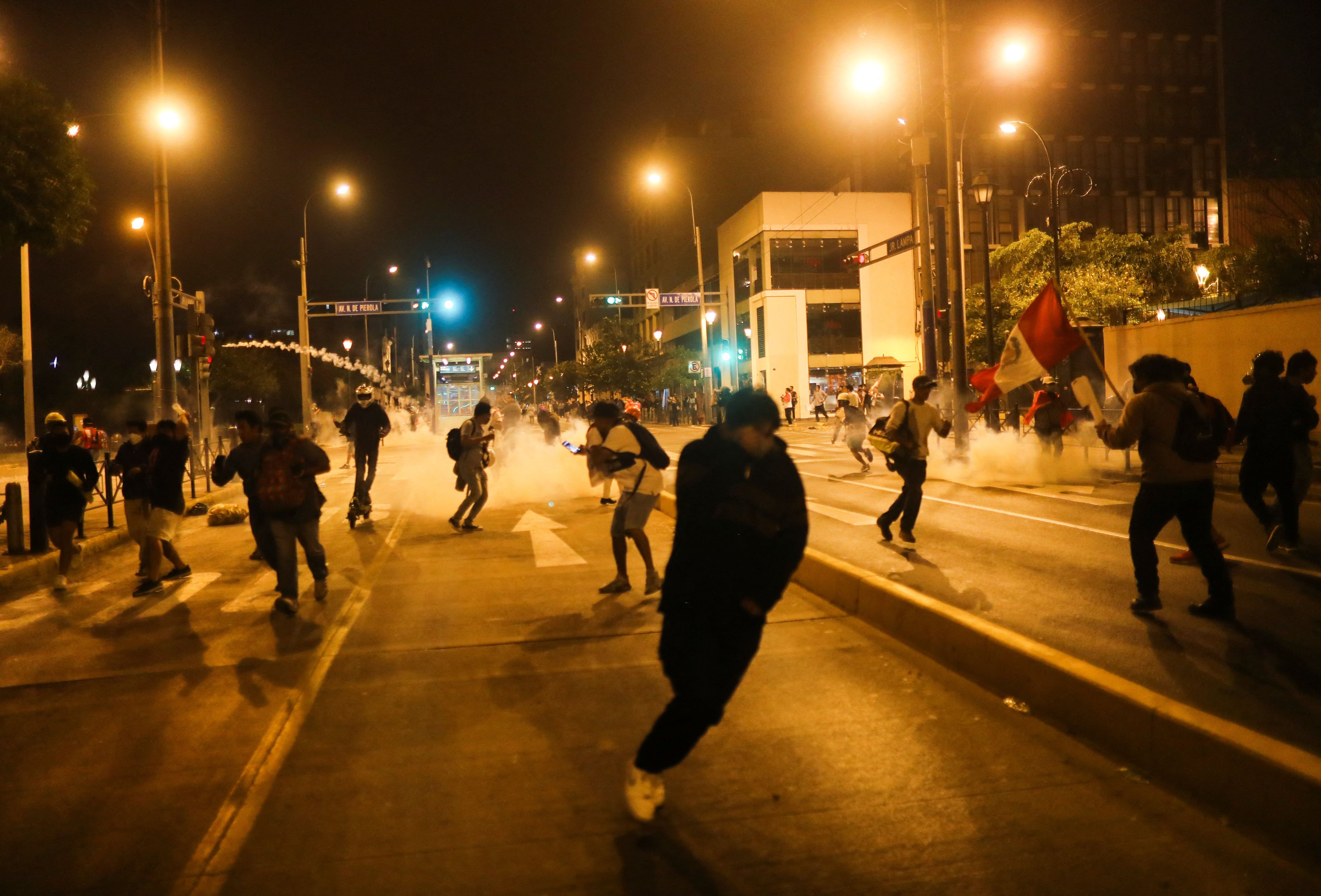 Demonstrators run from tear gas as they protest to demand the dissolution of Congress and to hold democratic elections rather than recognise Dina Boluarte as Peru's President, after the ousting of Peruvian President Pedro Castillo, in Lima, Peru December 12, 2022. REUTERS/Sebastian Castaneda