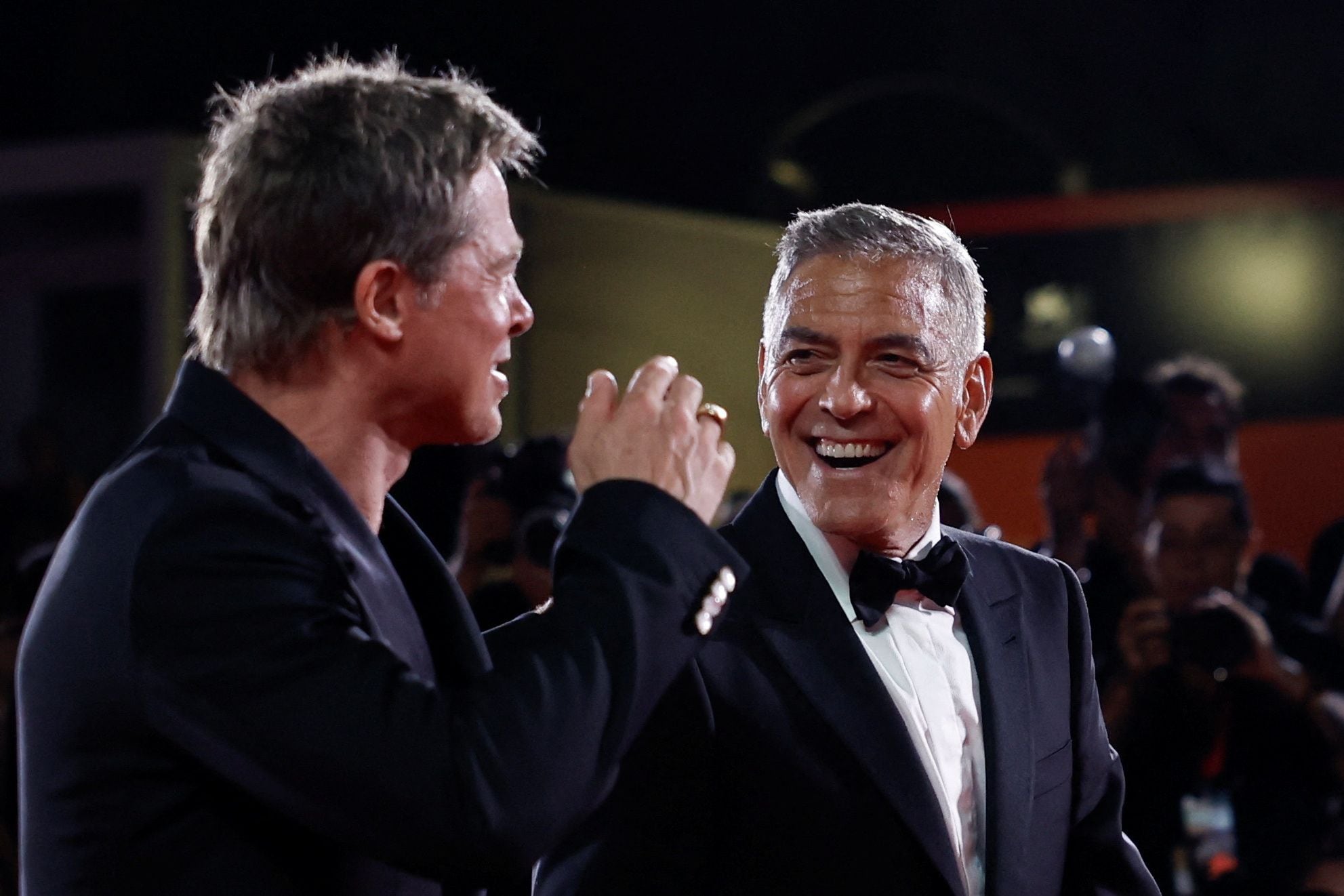 Brad Pitt and George Clooney pose on the red carpet during arrivals for the movie 