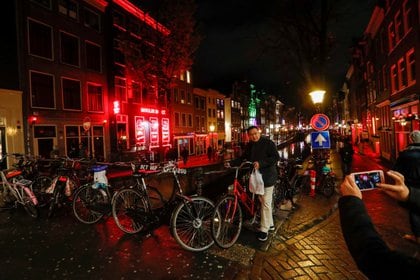 Un turista posa frente a un canal en el Barrio Rojo de Amsterdam (REUTERS/Yves Herman/Archivo)