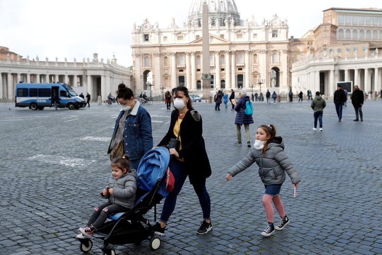 Una familia con barbijos camina en el Vaticano (REUTERS/Remo Casilli)