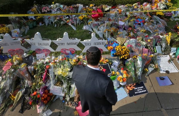 Una hombre, a las afueras de la sinagoga en Pittsburgh, rinde tributo a las víctimas de la masacre. (REUTERS/Cathal McNaughton)