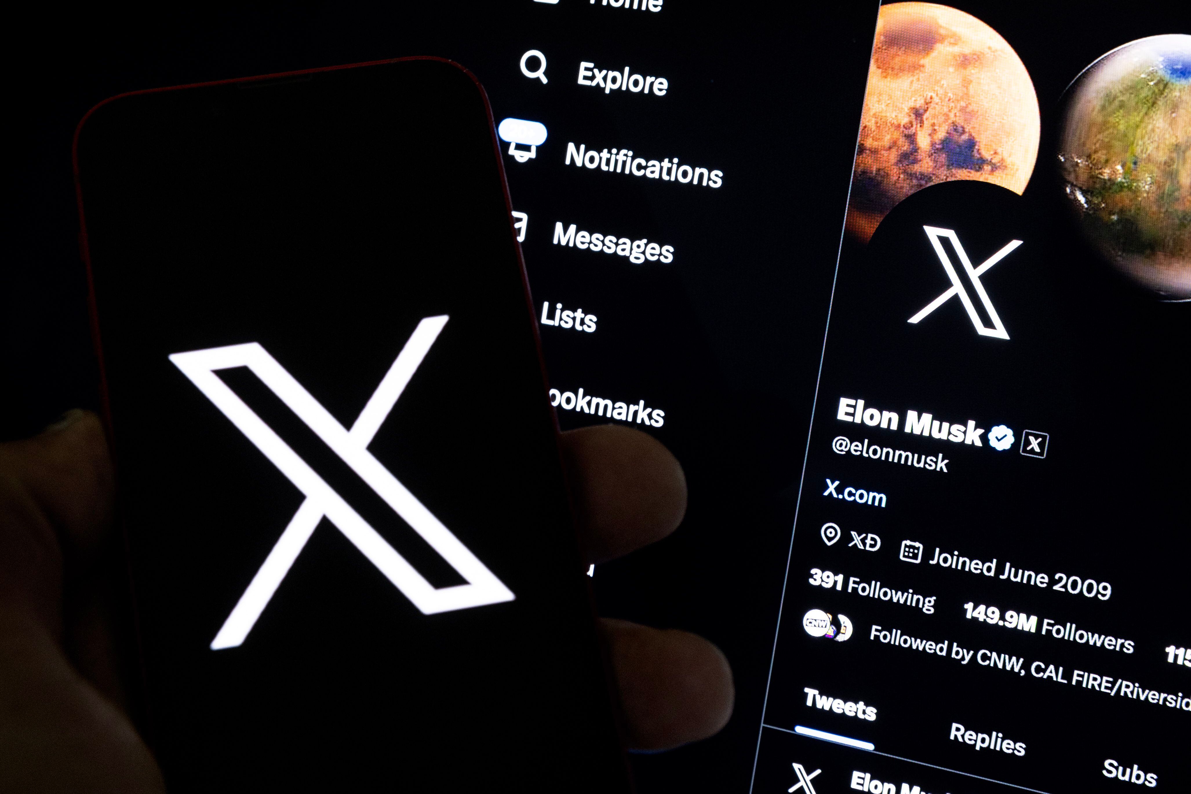Fotografía de archivo que muestra a un usuario sosteniendo un teléfono móvil que muestra el logotipo 'X' frente a una pantalla que muestra el perfil en esa misma red social de Elon Musk, en Los Ángeles, California (EE.UU.). EFE/ Etienne Laurent
