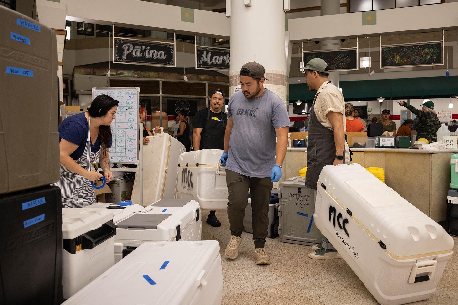 Los voluntarios preparan comidas gratis para donar a las familias del oeste de Maui afectadas por los incendios forestales, en el University of Hawaii Maui College en Kahului, en el centro de Maui, Hawaii, el 13 de agosto de 2023. (Foto de Yuki IWAMURA / AFP)