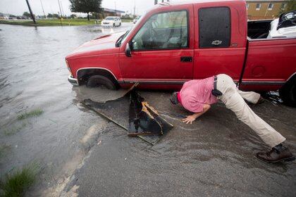 Felipe Morales trabalha em obter seu caminhão fora de uma vala cheia de água alta durante a chuva Stemming de faixas de chuva geradas pela tempestade tropical Imeld na terça-feira, setembro. 17, 2019, em Houston. Ele foi capaz de obter ajuda quando um homem com um caminhão ajudou a puxá-lo da vala. (Brett Coomer / Houston Chronicle via AP)