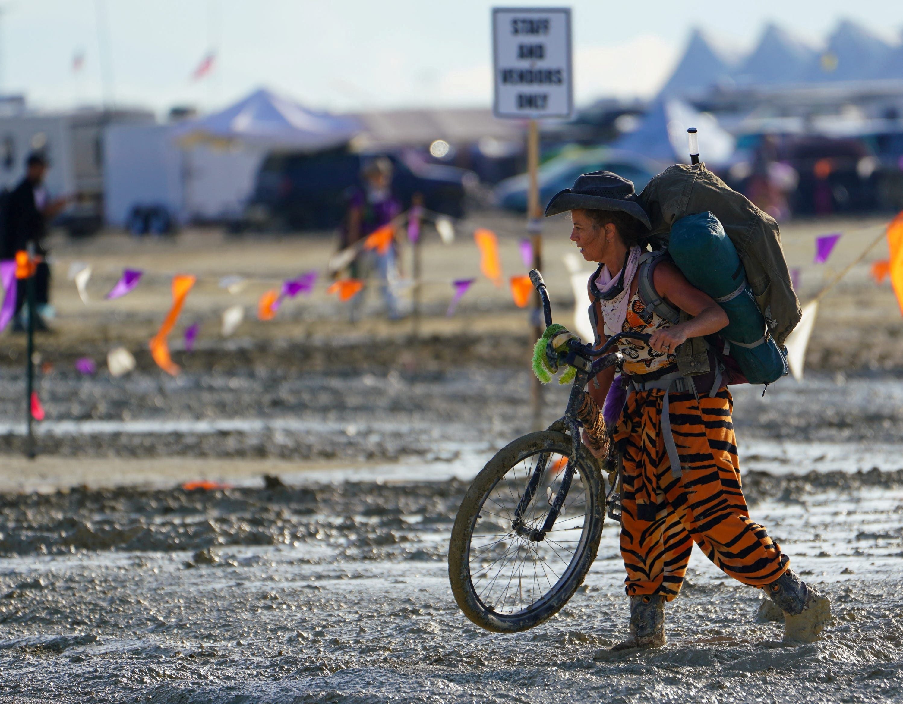 Un participante de Burning Man camina con su bicicleta por el barro cerca de la salida. Trevor Hughes/USA Today Red vía REUTERS.