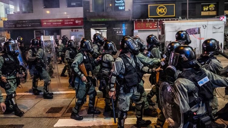 Oficiales de la policía antidisturbios disparan gases lacrimógenos durante un enfrentamiento con los manifestantes en Causeway Bay (Lam Yik Fei / The New York Times)