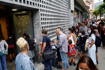 Una estrecha fila de padres e hijos esperando para ingresar a la escuela en el Colegio Pureza de Maria en Bilbao (REUTERS / Vincent West)