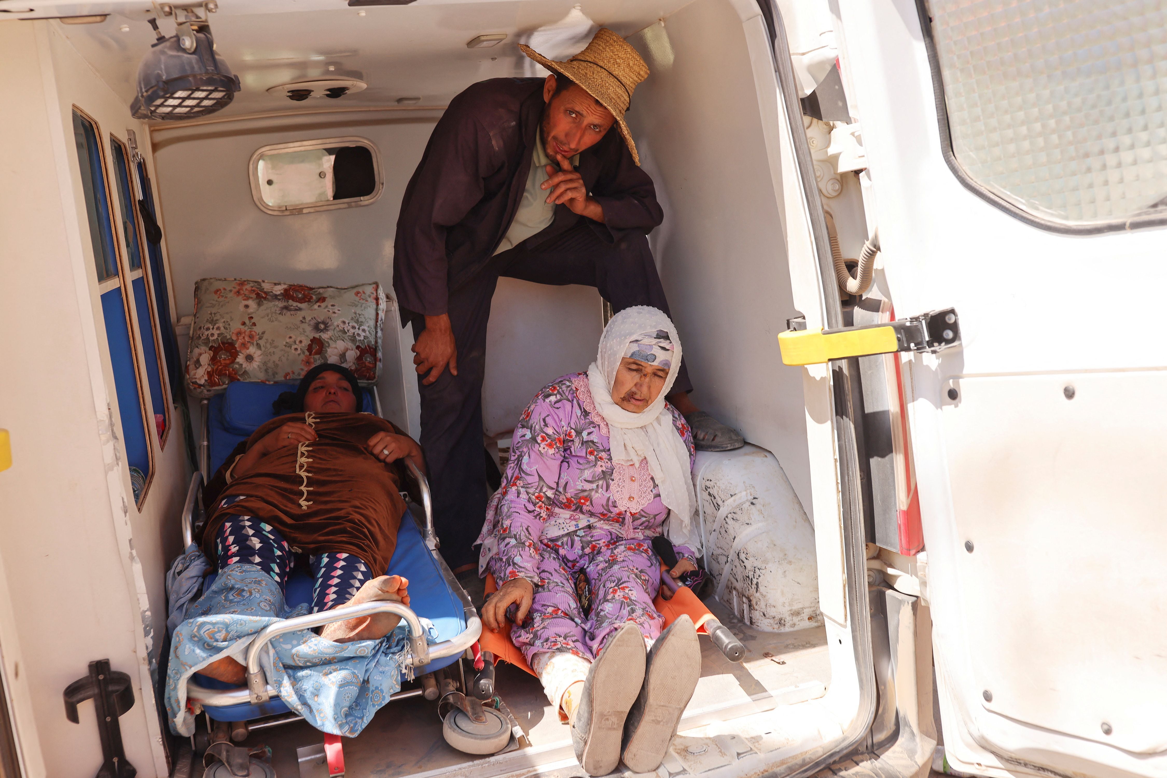 A man looks on, next to women who were rescued, in the back of an ambulance, in the aftermath of a deadly earthquake, in Amizmiz, Morocco, September 10, 2023. REUTERS/Nacho Doce