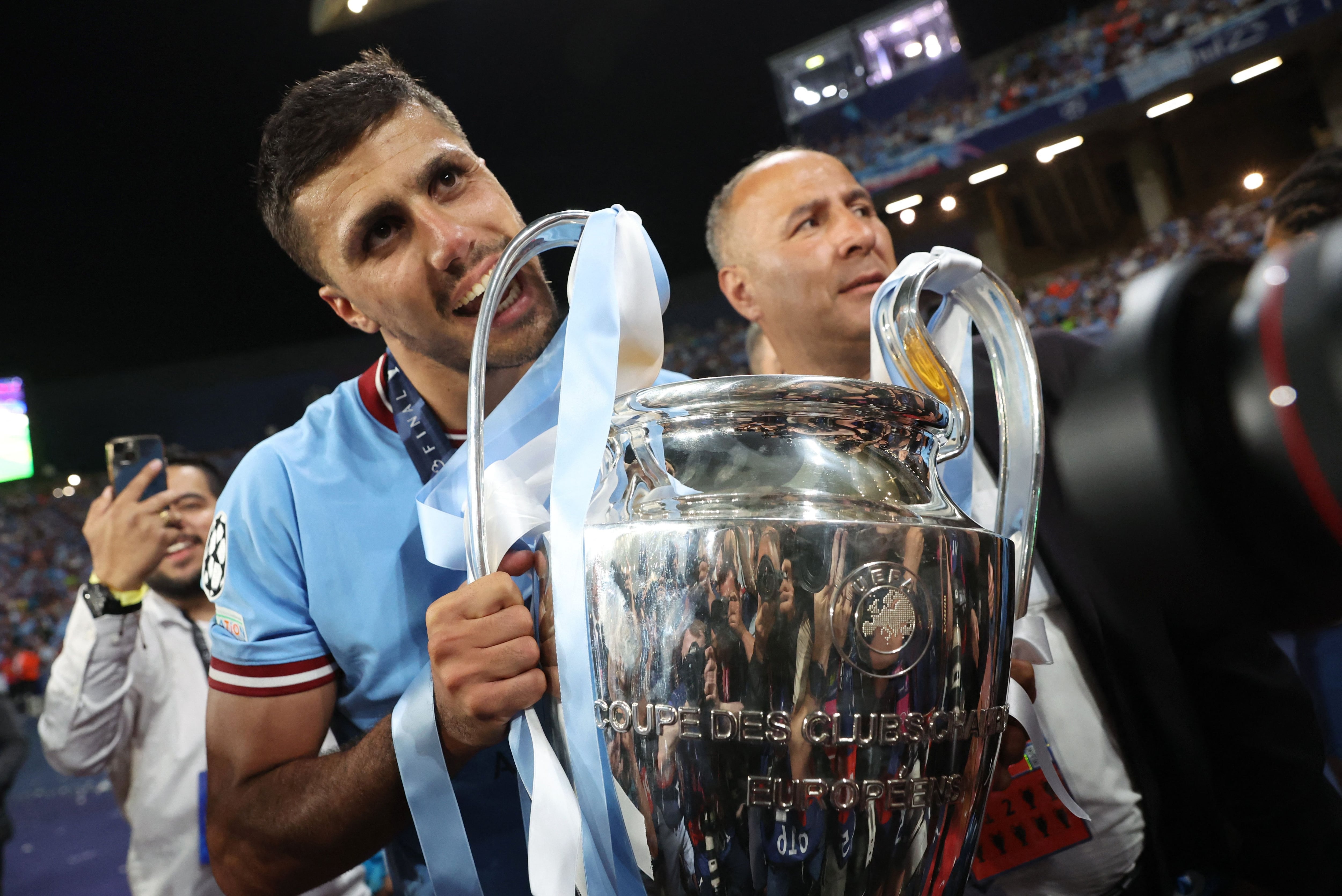 Rodri muerde el trofeo de la Champions League 2023 ganada por el Manchester City al Inter de Milán (REUTERS).
