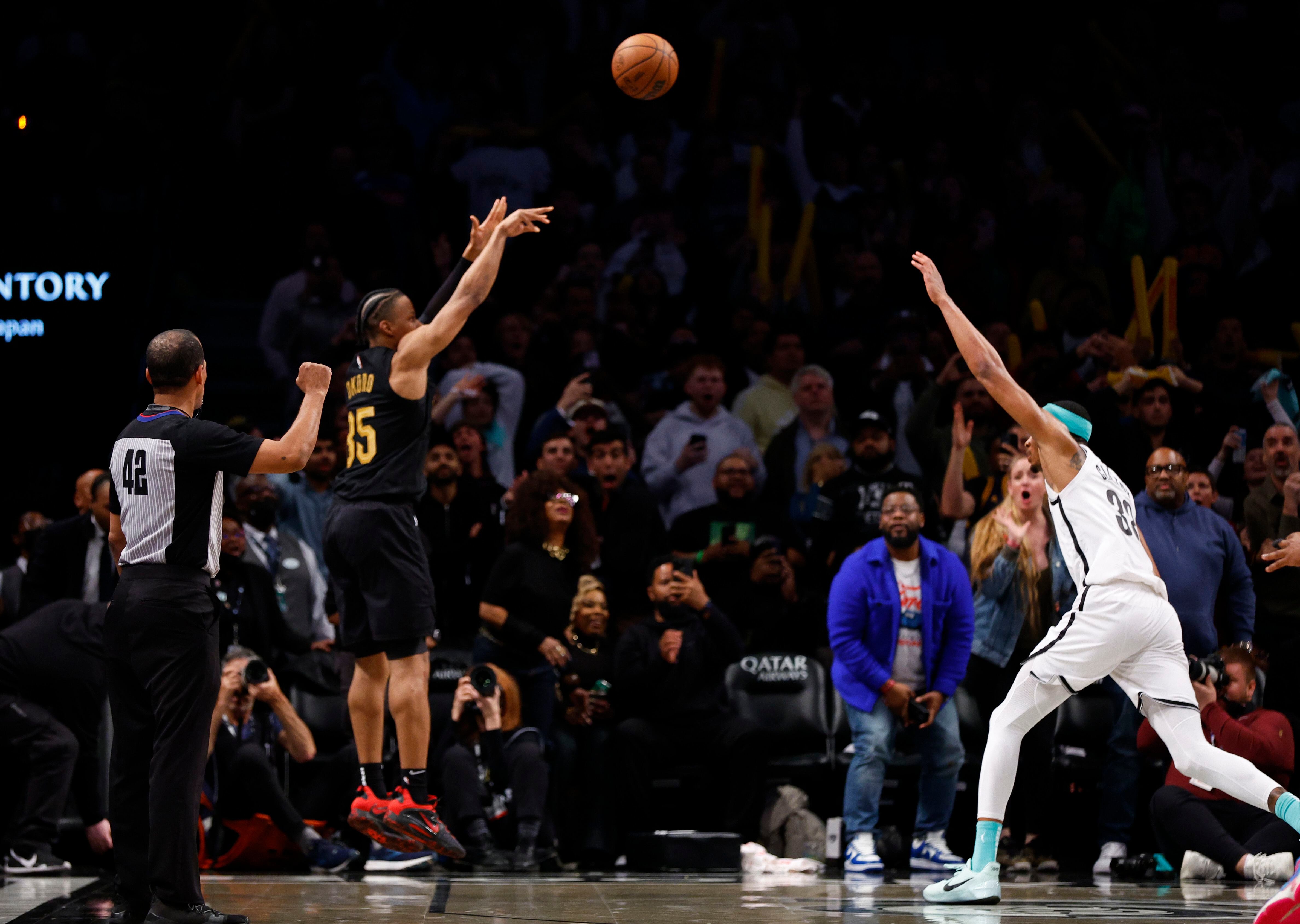 El alero de los Cavaliers de Cleveland Isaac Okoro anota el triple de la victoria frente el pívot de los Nets de Brooklyn Nic Claxton en el encuentro del jueves 23 de marzo del 2023. (AP Foto/Noah K. Murray)