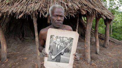 Un miembro de la tribu con una fotografía del príncipe Felipe en 1980 posando con el bastón que le enviaron a Londres (Reuters)