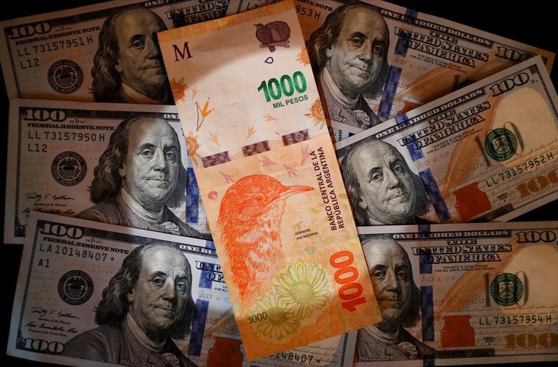 Foto de archivo - Un billete de mil pesos argentinos sobre varios billetes de 100 dólares estadounidenses en una ilustración en Buenos Aires, Argentina. Oct 17, 2022. REUTERS/Agustin Marcarian/Illustration