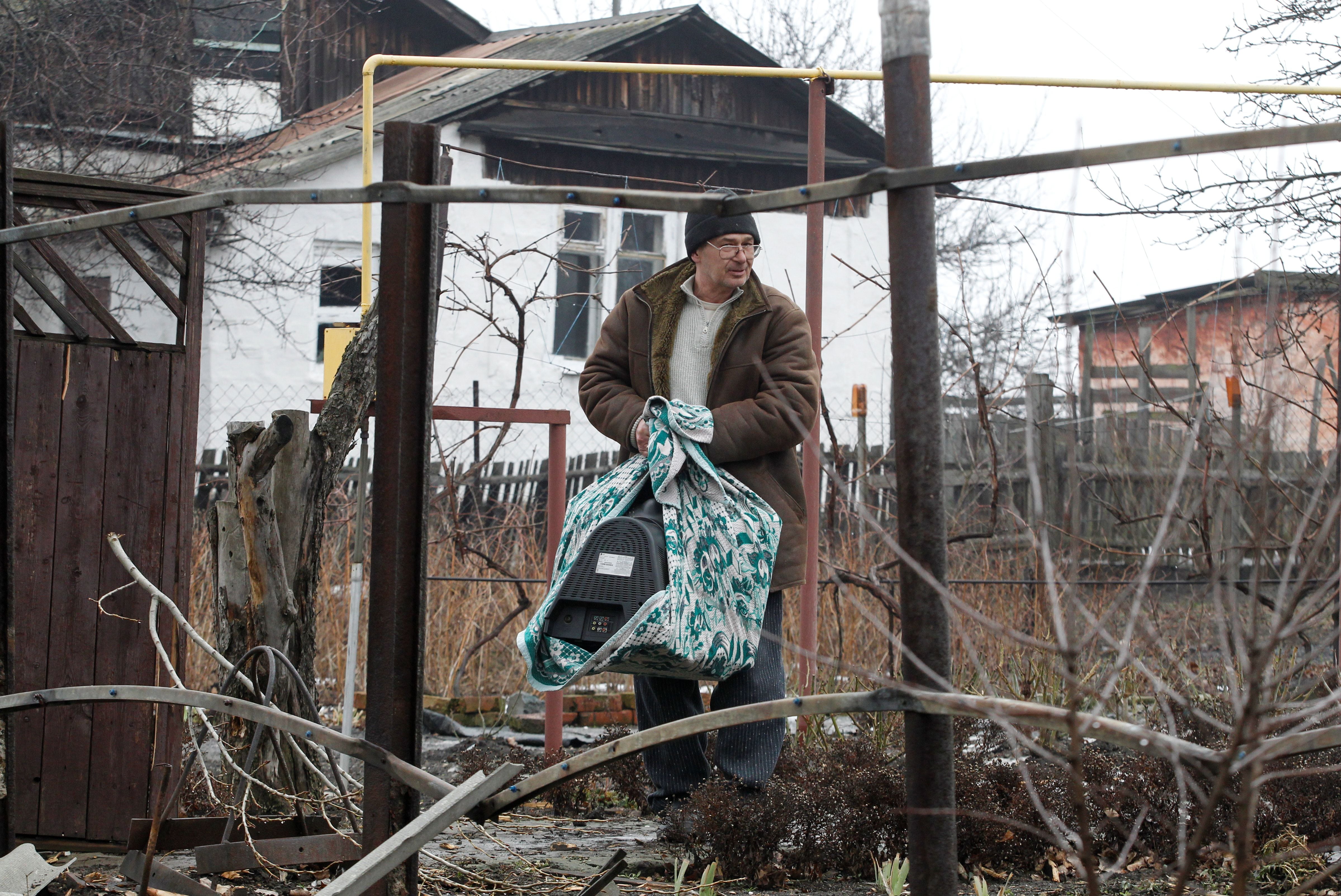 Un residente de Lugansk, sostiene un televisor antes de huir de su ciudad