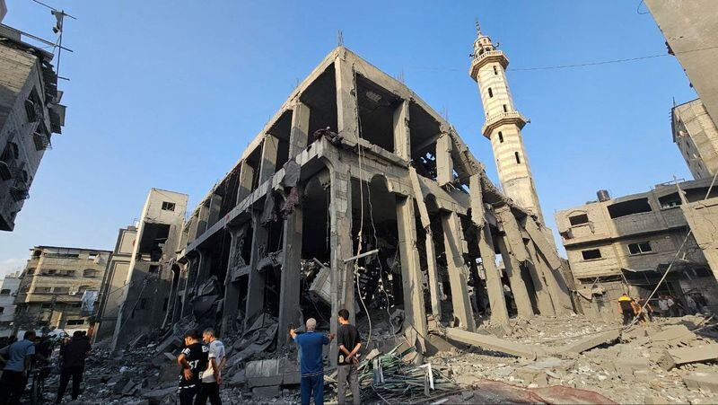 Palestinos se reúnen en torno a los restos de una mezquita destruida en el norte de la Franja de Gaza (Reuters)