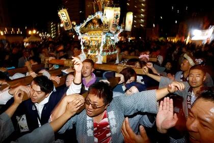 La gente lleva un 'Mikoshi' iluminado o santuario portátil durante un evento de cuenta regresiva para celebrar el año nuevo en Yokosuka, al sur de Tokio, el 1 de enero de 2024. REUTERS/Kim Kyung-Hoon
