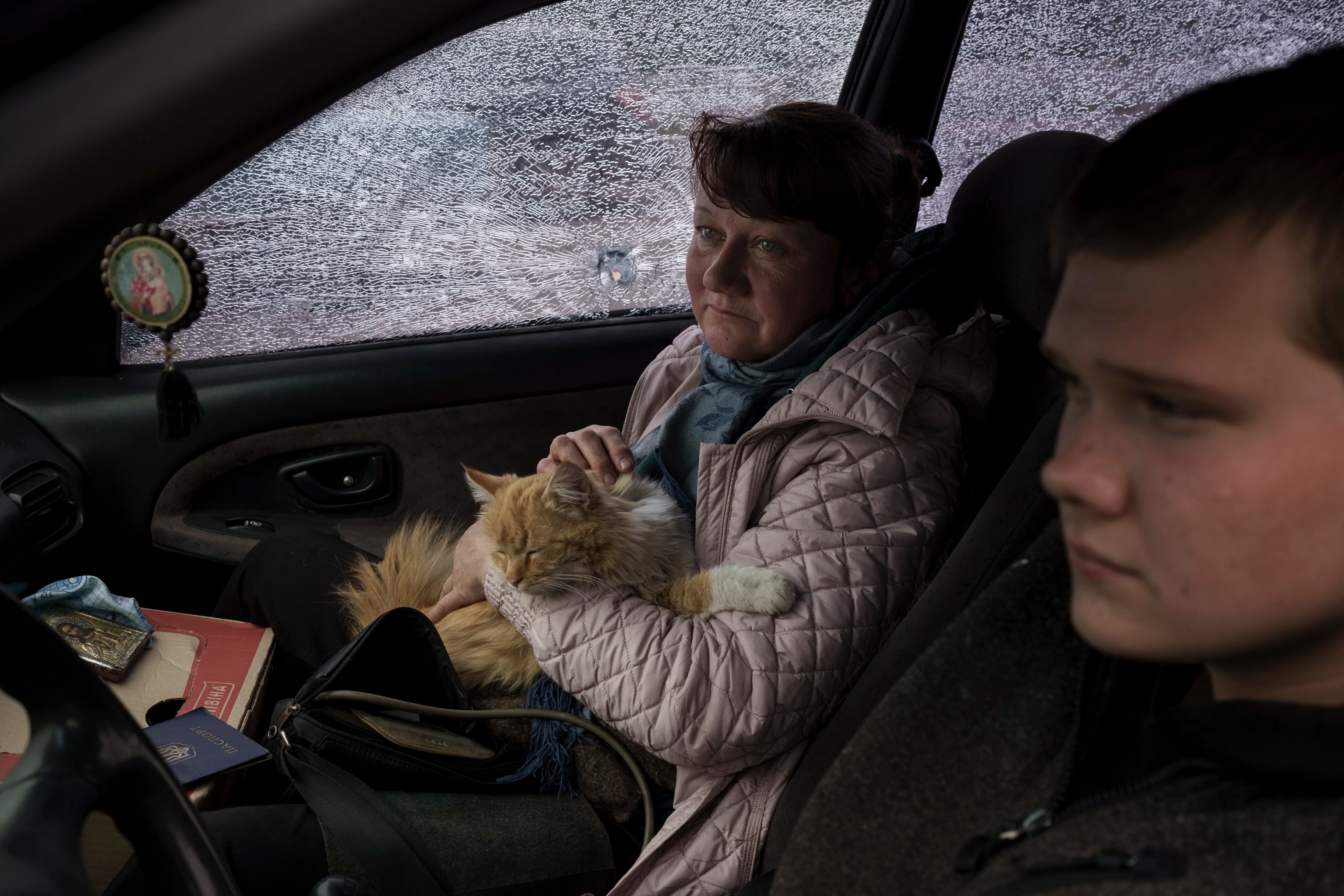 Una familia que huye del pueblo de Ruska Lozova llega en su automóvil lleno de metralla a un punto de detección en Kharkiv, Ucrania, el viernes 29 de abril de 2022.