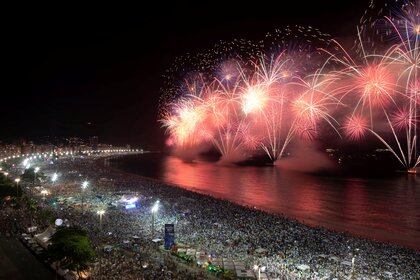 La gente observa cómo los fuegos artificiales explotan en la playa de Copacabana durante las celebraciones de Año Nuevo en Río de Janeiro, Brasil, 1 de enero de 2020. REUTERS / Ueslei Marcelino