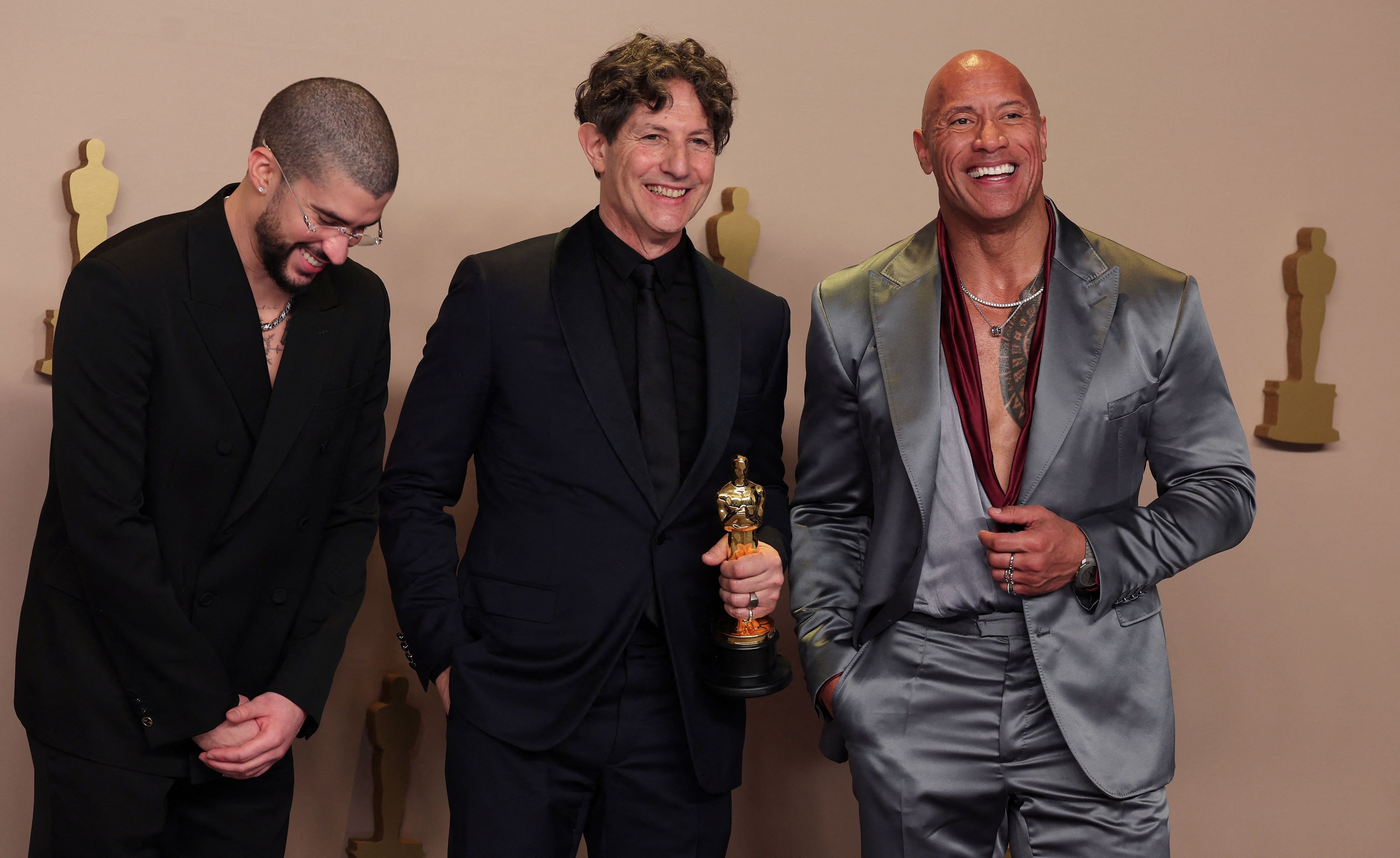 Jonathan Glazer, director de Zona de Interés, posa entre Dwayne Johnson y Bad Bunny quienes le entregaron el Oscar a la mejor película internacional (REUTERS/Carlos Barria)