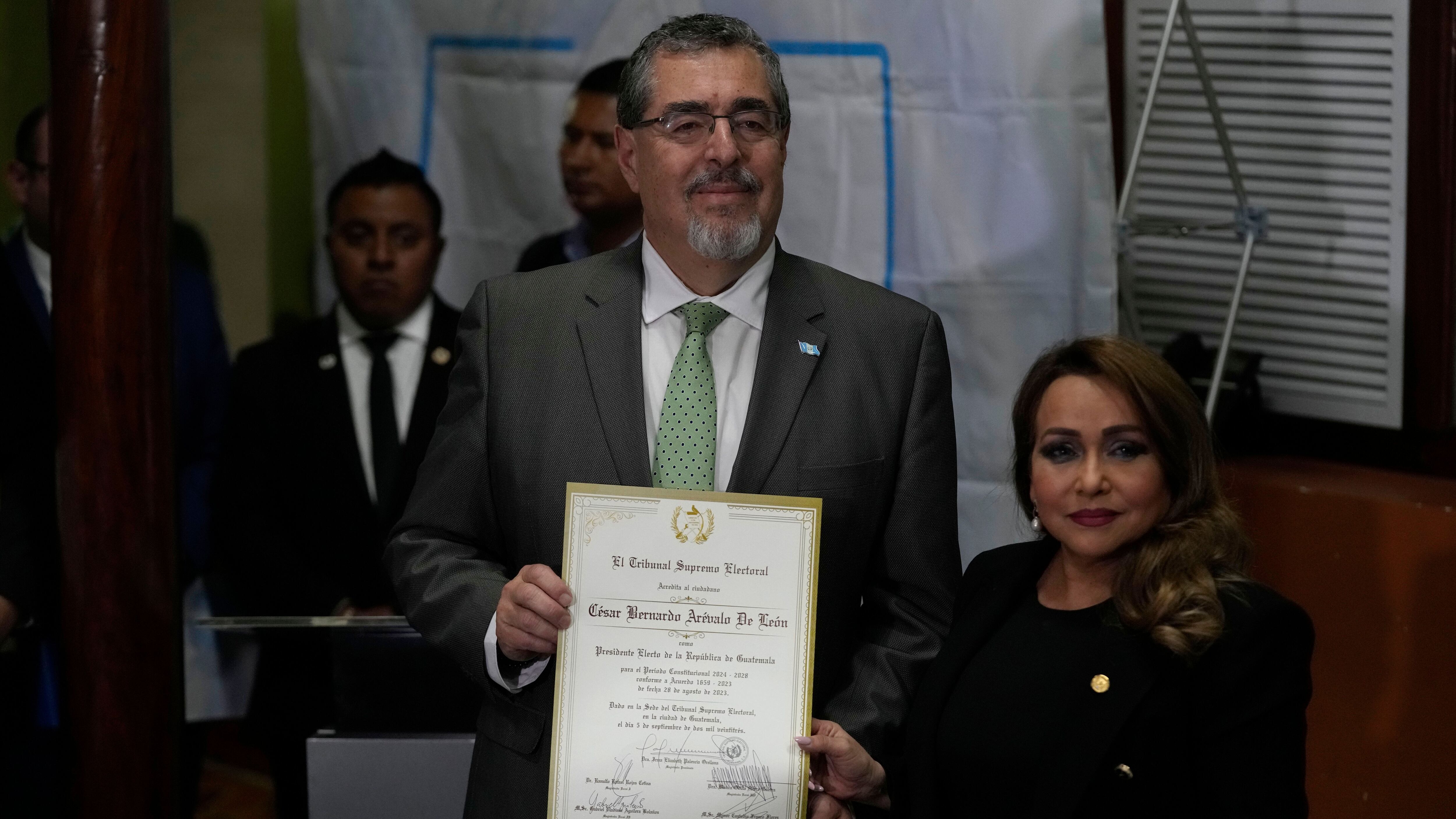 El presidente electo, Bernardo Arévalo, posa junto a la presidenta del Tribunal Supremo Electoral, Irma Palencia, después de que el TSE le entregara su credencial como ganador de las elecciones (AP Foto/Moisés Castillo)