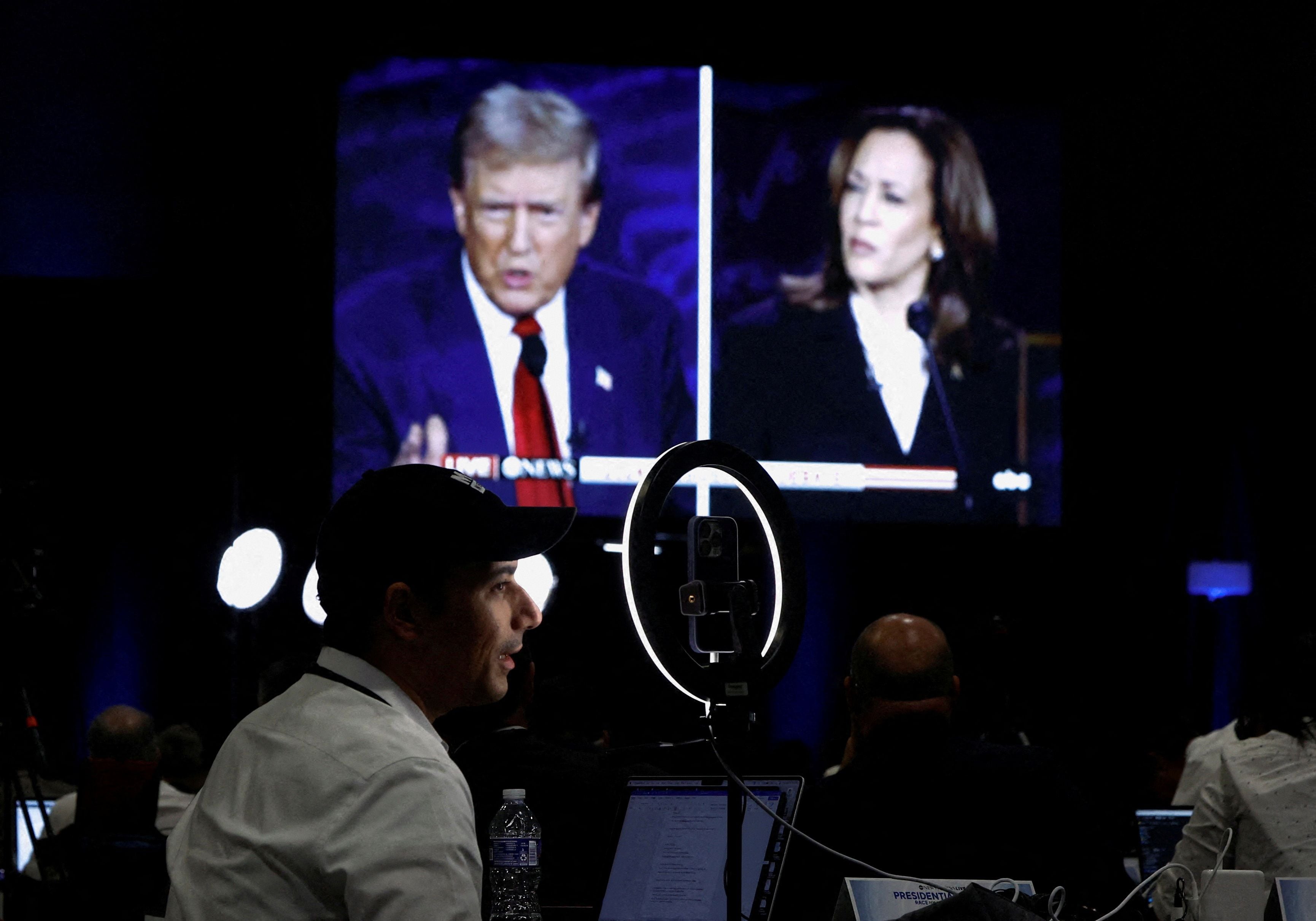 FILE PHOTO: Members of the media use a screen to watch the presidential debate, as Republican presidential nominee, former U.S. President Donald Trump and Democratic presidential nominee, U.S. Vice President Kamala Harris attend a presidential debate hosted by ABC in Philadelphia, Pennsylvania, U.S., September 10, 2024. REUTERS/Evelyn Hockstein/File Photo