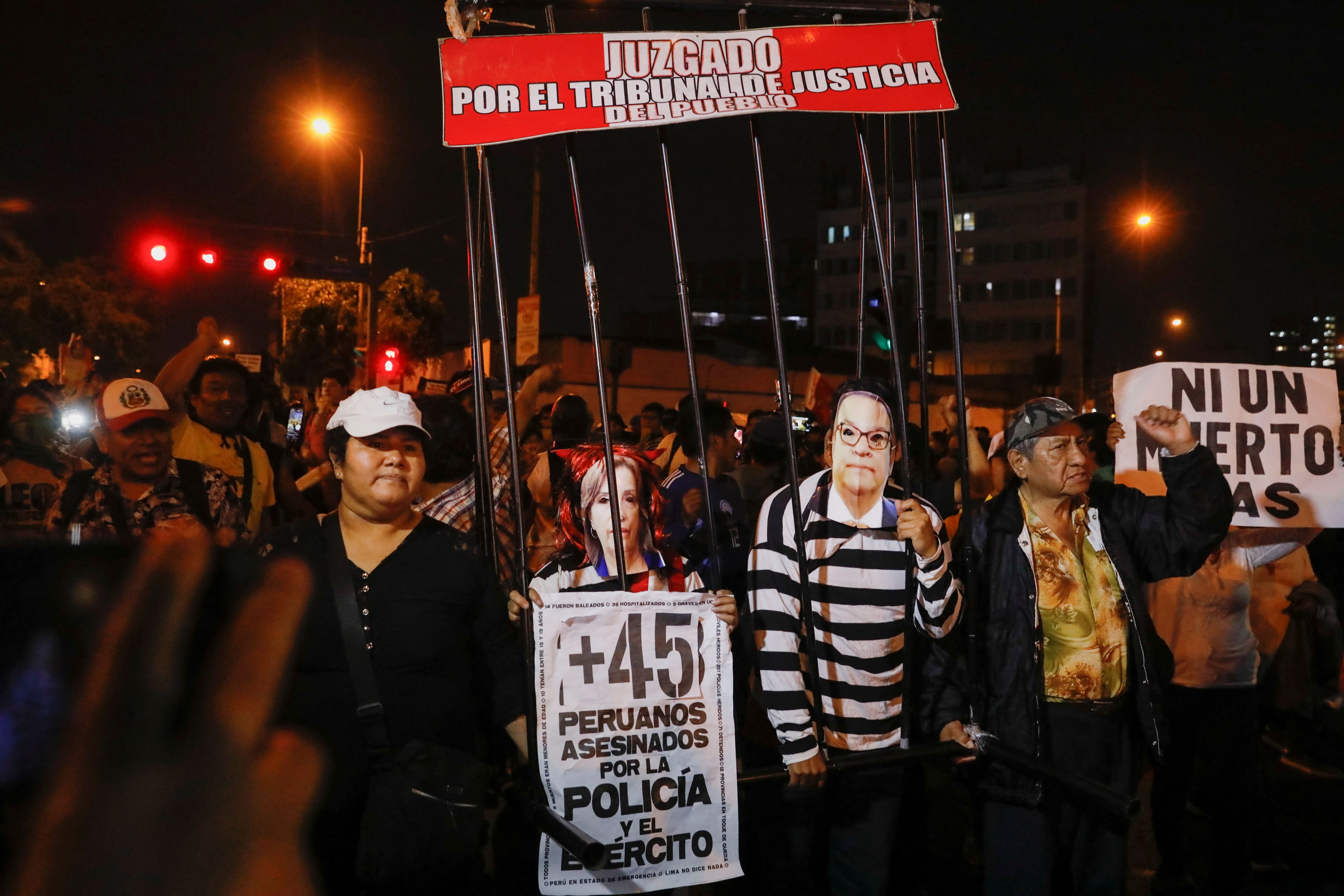 Demonstrators carry banners and images depicting Peru's President Dina Boluarte and Prime Minister Alberto Otarola during a protest to demand the dissolution of Congress and democratic elections, rejecting the new government, after the ouster of leftist President Pedro Castillo, in Lima, Peru January 12, 2023. REUTERS/Alessandro Cinque