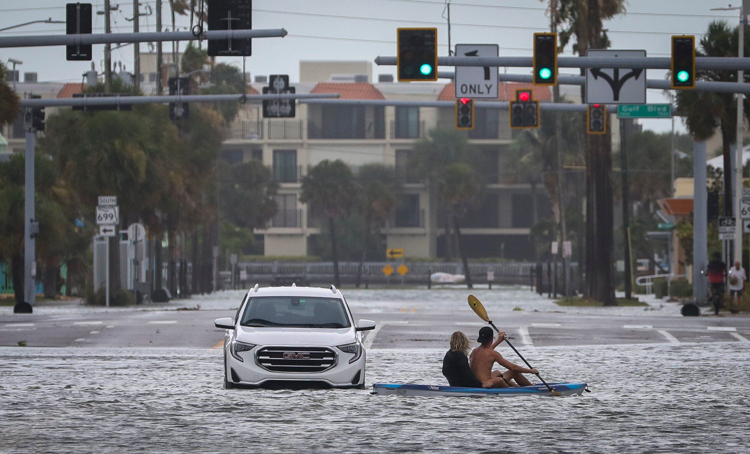 
Un hombre y una mujer pasan en kayak por un vehículo abandonado en la intersección de Boca Ciega Drive y Pasadena Avenue en St. Pete Beach. Foto: Chris Urso/Tampa Bay 