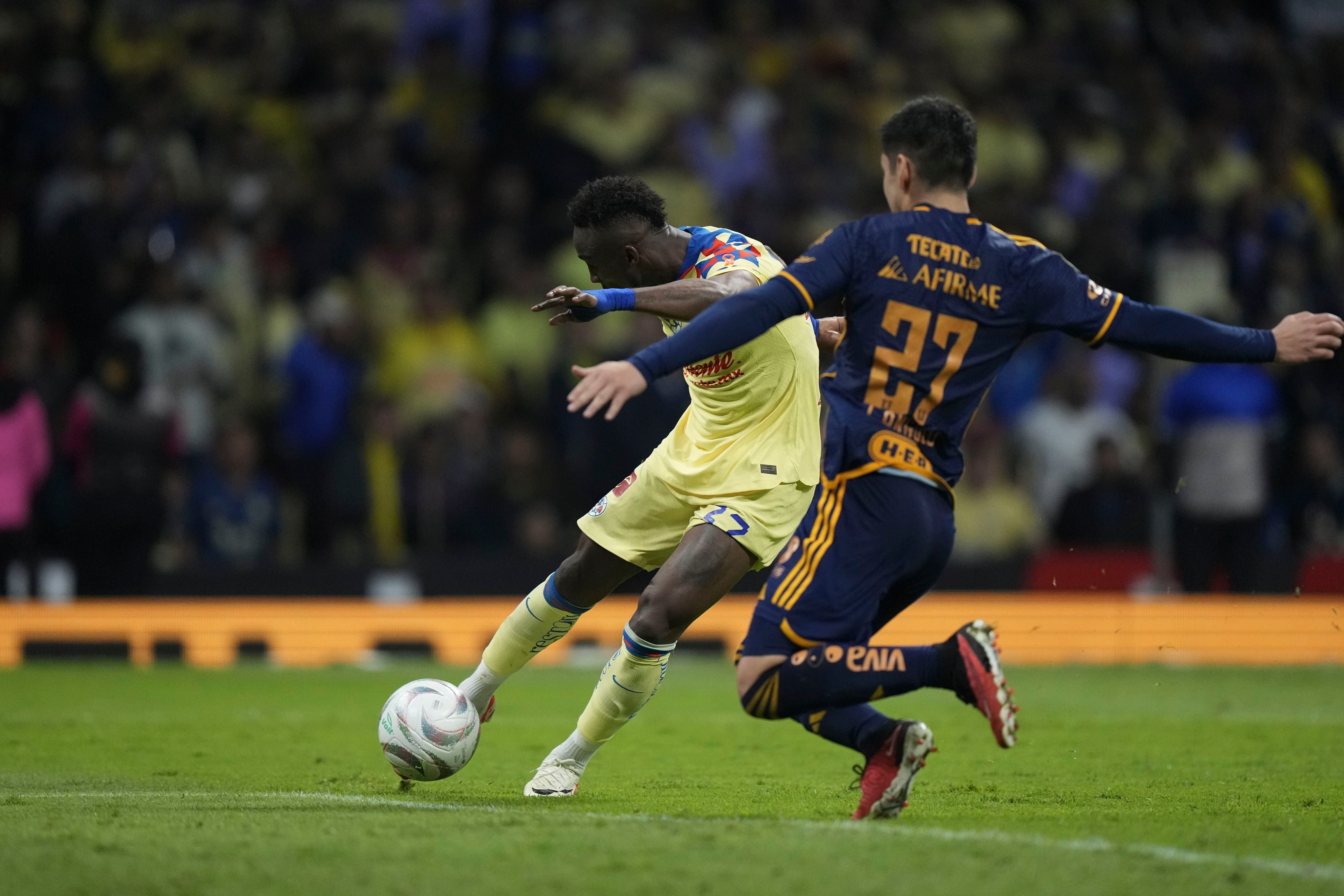 Julián Quinones, izquierda, anota el primer gol del América en contra de Tigres durante la final del fútbol mexicano, en el partido de vuelta en el Estadio Azteca, en la Ciudad de México, el domingo 17 de diciembre de 2023. (AP Foto/Fernando Llano)