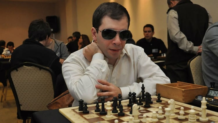 López, unos años atrás,  frente a un tablero adaptado para los no videntes. Entre las diferencias, los escaques blancos tienen diferente altura que los negros