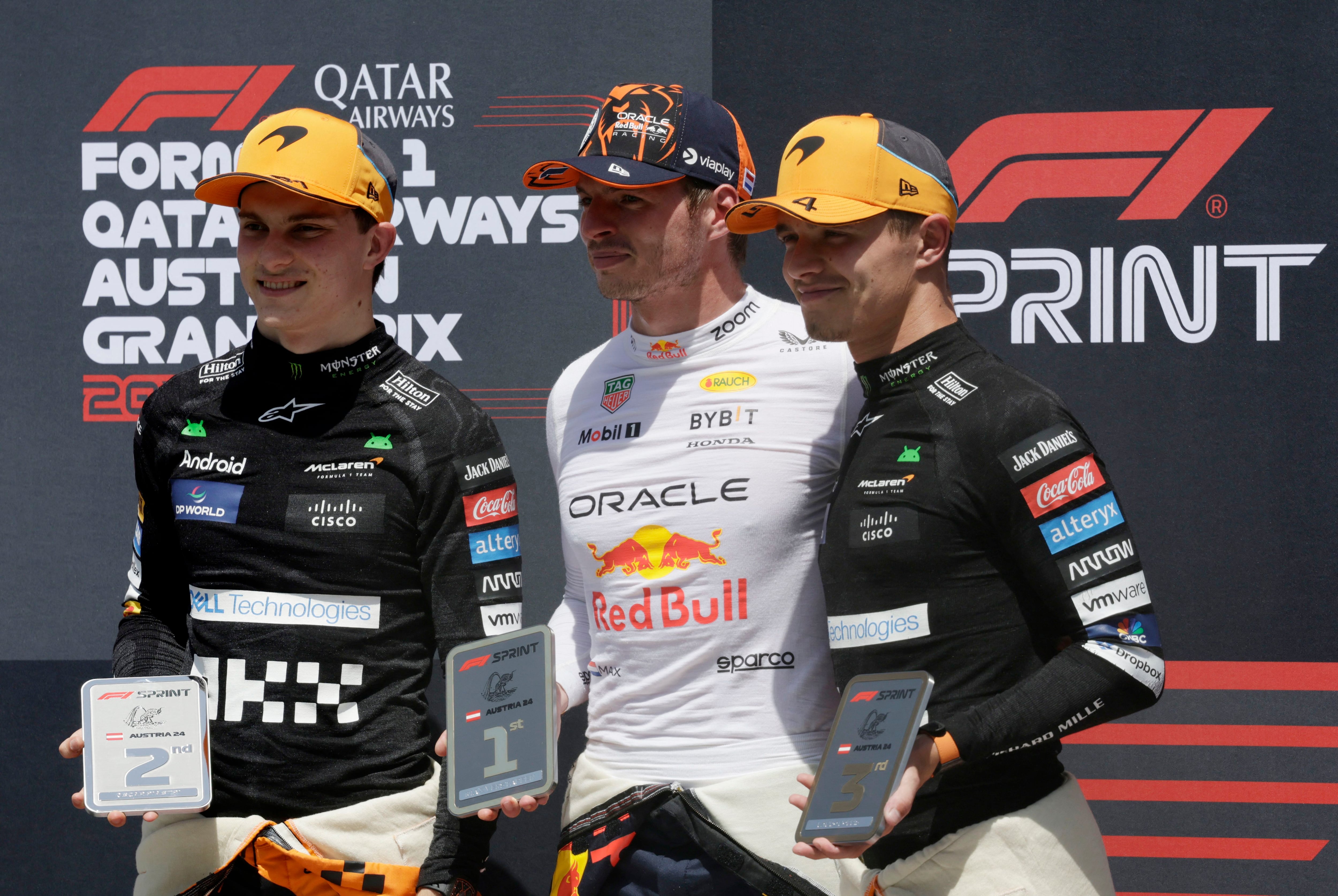 Max Verstappen de Red Bull celebra con el trofeo en el podio después de ganar la carrera sprint de Austria con Oscar Piastri y Lando Norris, ambos de McLaren, en los otros dos lugares (Foto: Reuters/Leonhard Foeger)