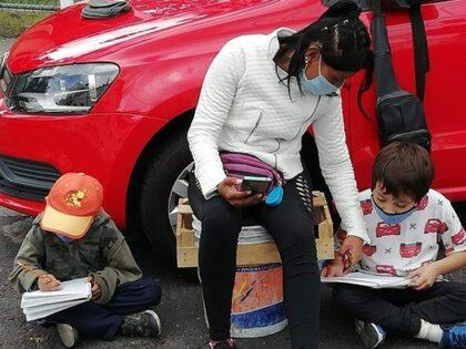 Una mujer que cuida coches llevó con ella a sus hijos para estudiar con el internet gratuito de las cámaras de seguridad C5 en la Ciudad de México Foto: (Facebook)