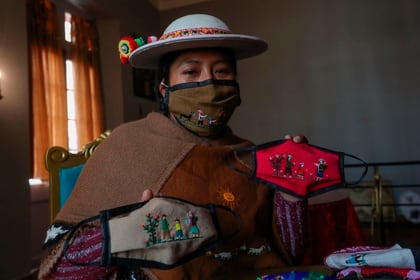 La indígena Ana Alicia Layme, de la comunidad Ayata, muestra tapabocas bordados en La Paz (Bolivia) (EFE/Martín Alipaz)