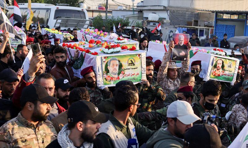Manifestantes llevan los ataúdes de los combatientes iraquíes de Kataib Hezbollah que murieron por un ataque aéreo estadounidense en Jurf al-Sakhar, al sur de Bagdad, durante un funeral en Bagdad (REUTERS/Thaier Al-Sudani)