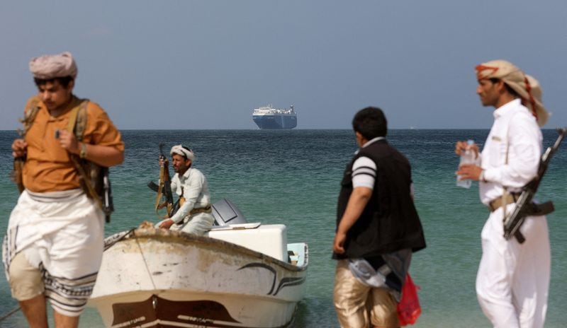 FOTO DE ARCHIVO: Hombres armados en la playa mientras el buque comercial Galaxy Leader, incautado por los hutíes de Yemen el mes pasado, está anclado frente a la costa de al-Salif, Yemen (Reuters)