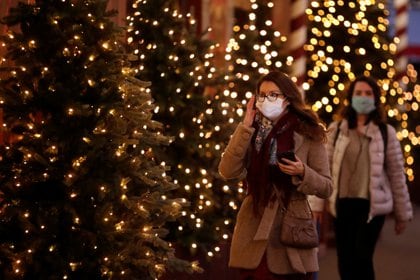 Personas con mascarilla protectora caminan junto a árboles de Navidad iluminados en una calle de París, Francia, el 12 de noviembre de 2020. REUTERS/Gonzalo Fuentes
