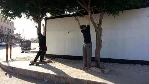 Los cuerpos de dos hombres ejecutados, exhibidos en las calles de Deir Hafer durante la ocupación del ISIS (Twitter/@ProSyriana)