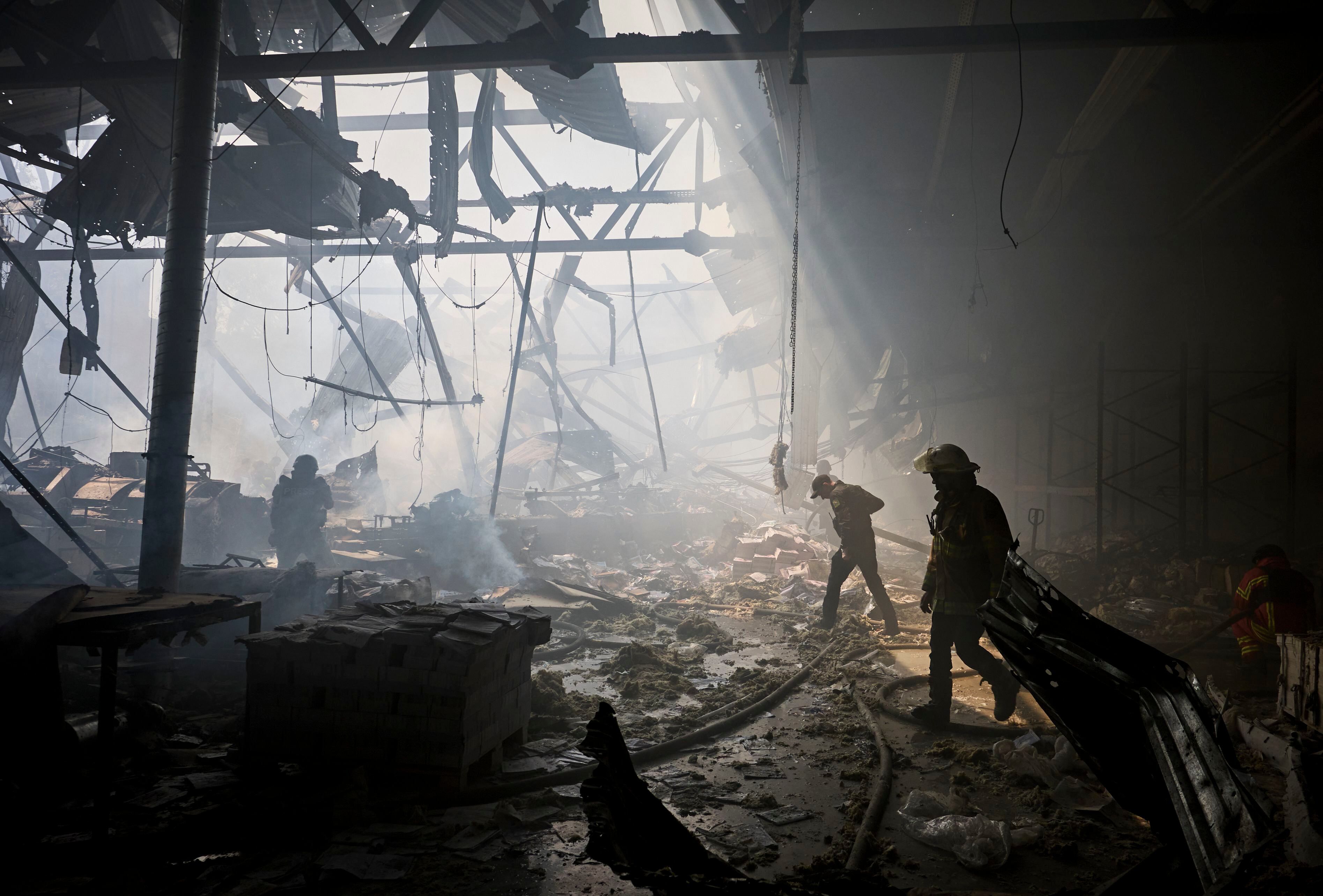 Rescatistas ucranianos trabajan en el lugar de un bombardeo contra una imprenta en Kharkiv, Ucrania, el 23 de mayo (EFE/ Sergey Kozlov)