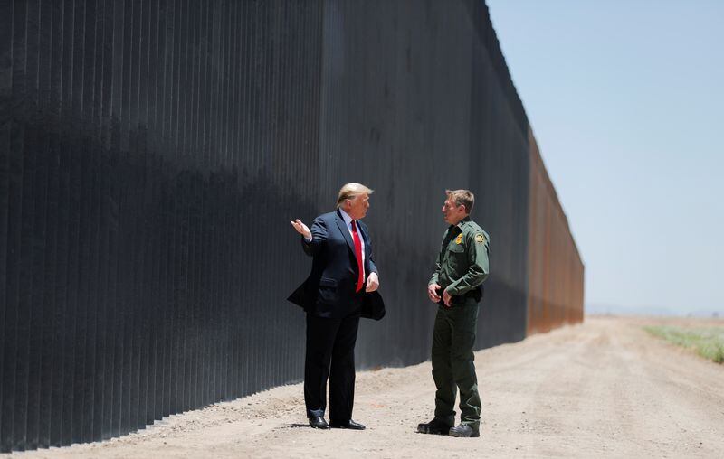Trump junto al entonces jefe de la Patrulla Fronteriza, Rodney Scott, mientras recorre una sección del muro que mandó a construir en la frontera con México. (REUTERS/Carlos Barría)