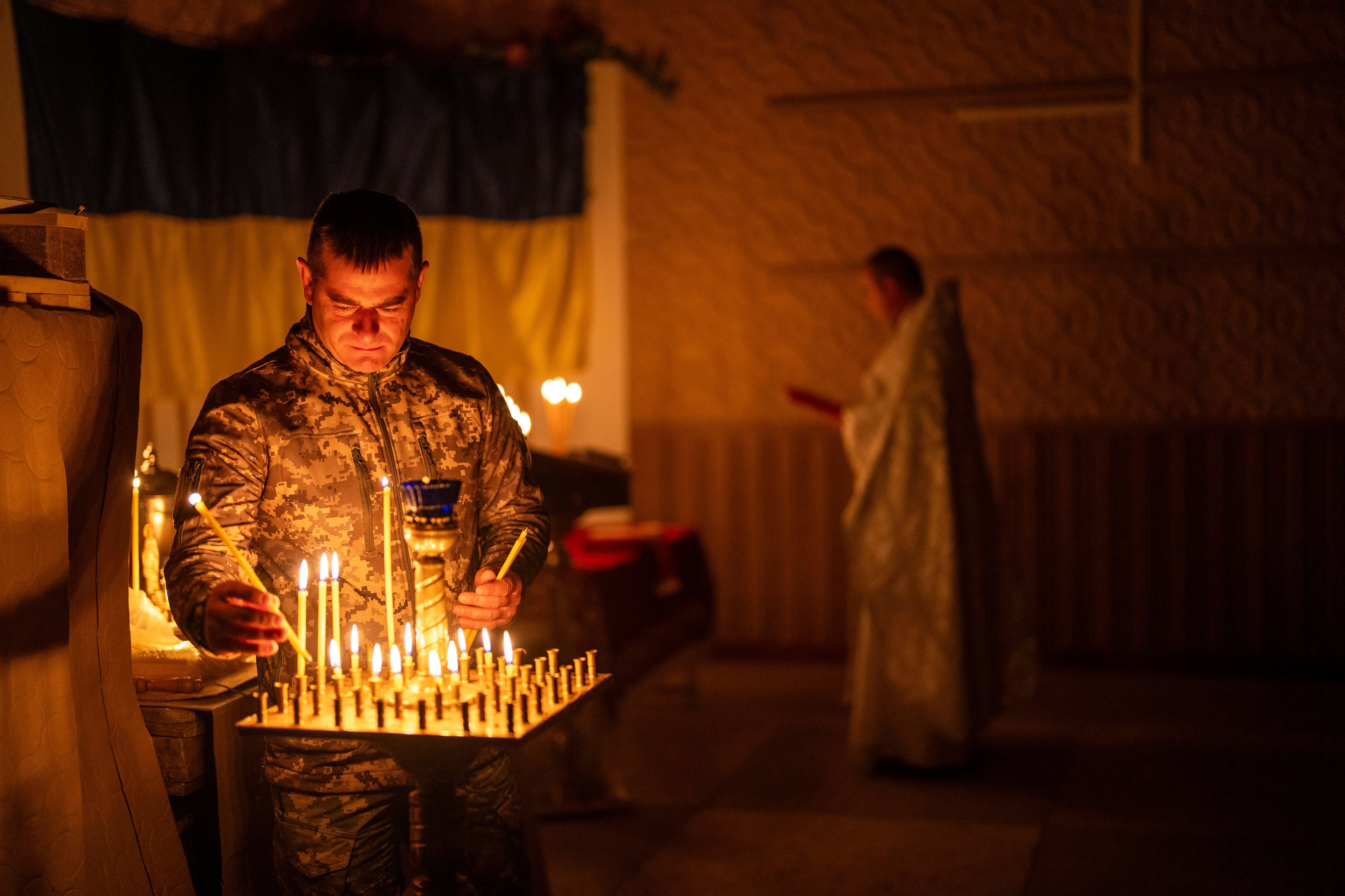 Un militar ucraniano de la 72da Brigada Mecanizada Separada enciende velas durante una ceremonia de la Pascua ortodoxa cristiana, en la región de Donetsk (AP Foto/Francisco Seco)