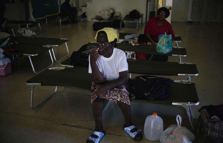 Dos mujeres sentadas en catres dentro de una iglesia empleada como refugio para los vecinos, que esperarán allí a que pase el huracán Dorian, en Freeport, Gran Bahama (AP Foto/Ramón Espinosa)