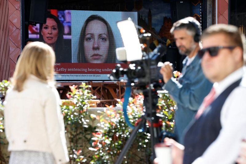 Periodistas trabajan cerca de una gran pantalla que muestra una imagen de la enfermera Lucy Letby, antes de su sentencia (Reuters)