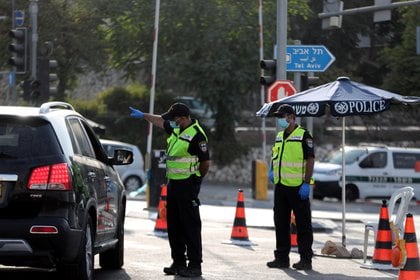 La policía israelí revisa un automóvil en un puesto de control después de que Israel ingresó a un segundo bloqueo nacional en medio de un resurgimiento de nuevos casos de enfermedad por coronavirus (COVID-19), lo que obligó a los residentes a permanecer principalmente en casa durante el pico de la temporada. de las fiestas judías a la entrada de Jerusalén.  REUTERS / Ronen Zvulun