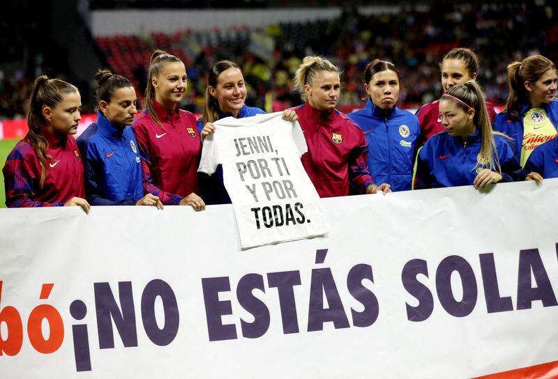 Jugadoras del FC Barcelona y del Club América con un cartel de apoyo a Jennifer Hermoso (REUTERS/Henry Romeros)