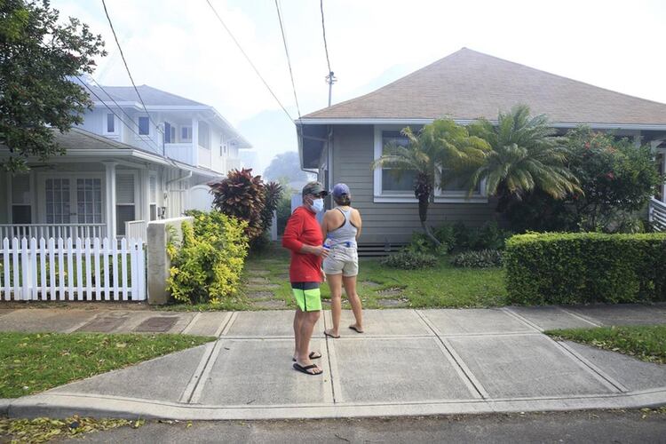 Vecinos se cubren con barbijos para protegerse de los gases de las viviendas. Varias personas fueron atendidas por el humo (AP)