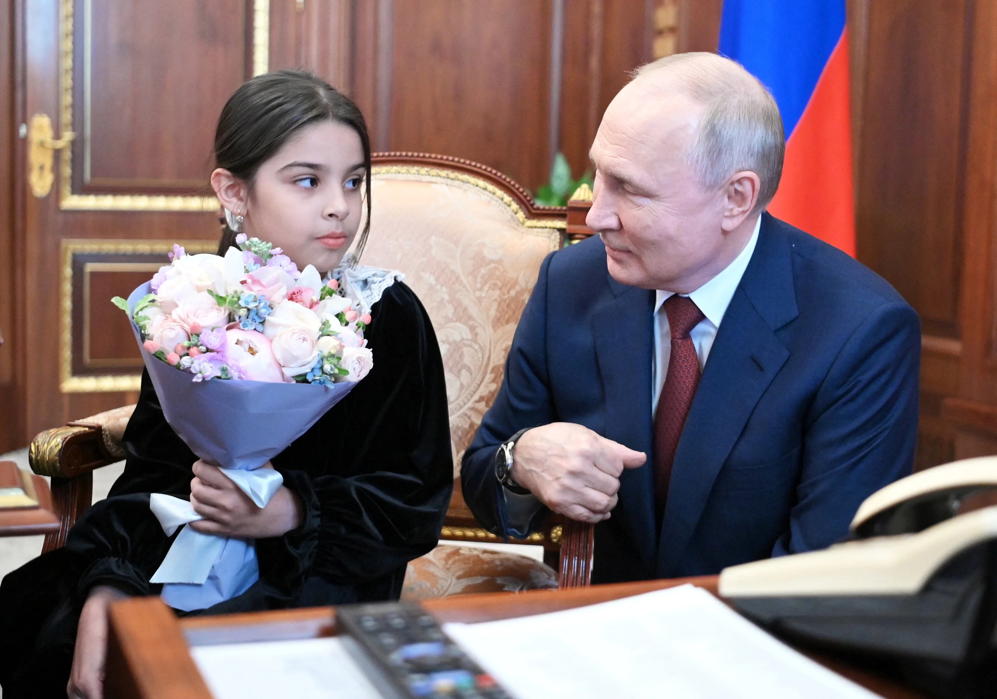 Tierno encuentro de Putin con la niña, Raisat Akipova, de 8 años, que había querido conocerlo durante su viaje de propaganda a Dagestán. La recibió en el Kremlin como parte de su campaña de acercamiento a la gente tras el motín. (Sputnik/Alexander Kazakov/Kremlin via REUTERS).